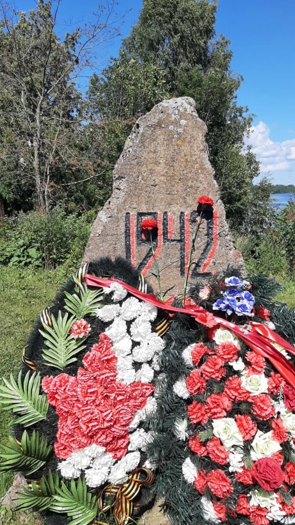 Памятный камень 1942 года в Невской Дубровке с венками